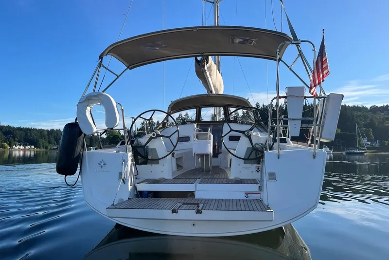 Slide: The Image of 2016 Jeanneau Sun Odyssey 349 sailboat with dual steering wheels, docked on calm water. - 36