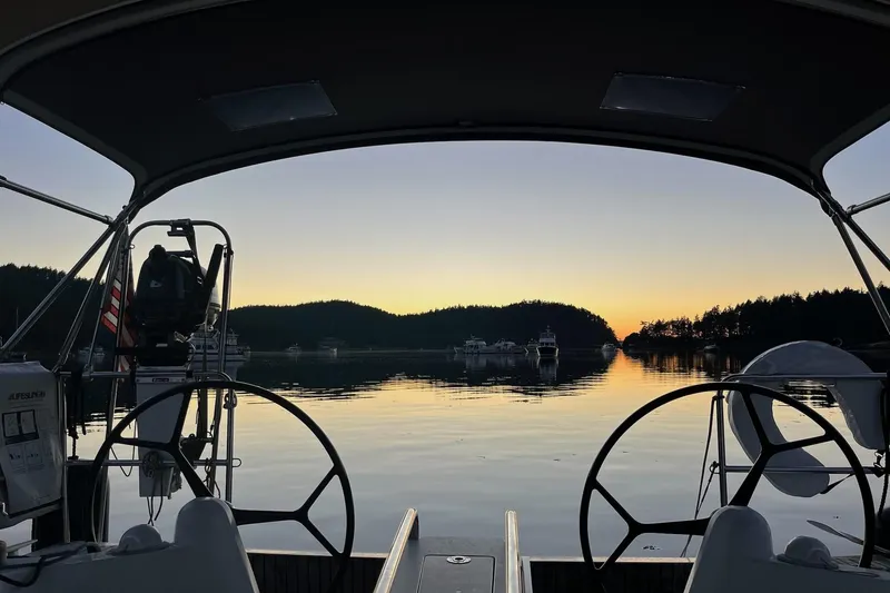Slide: The Image of 2016 Jeanneau Sun Odyssey 349 sailboat at sunset, serene water and distant boats. - 38