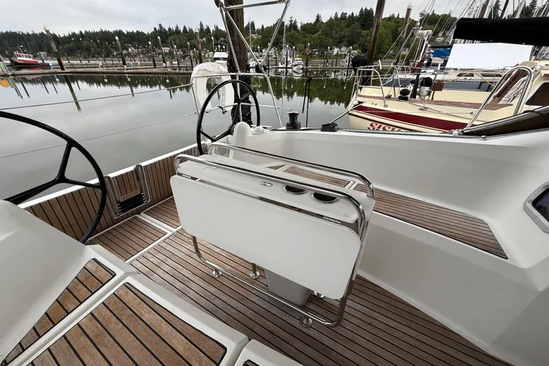Slide: The Image of 2016 Jeanneau Sun Odyssey 349 sailboat cockpit with dual steering wheels, docked in a marina. - 4