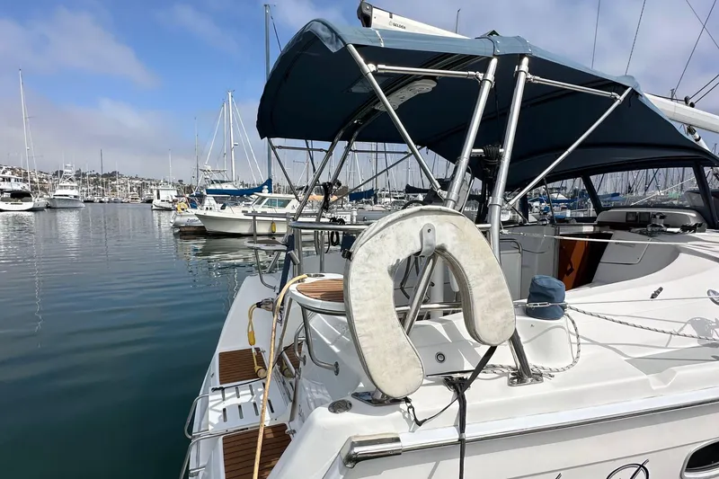 Slide: The Image of 2008 Hunter 36 sailboat docked in marina, featuring blue canopy and life preserver. - 10