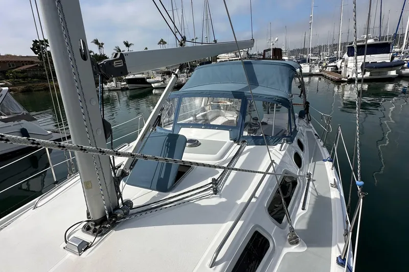 Slide: The Image of 2008 Hunter 36 sailboat docked in marina, featuring blue canopy and sleek design. - 19