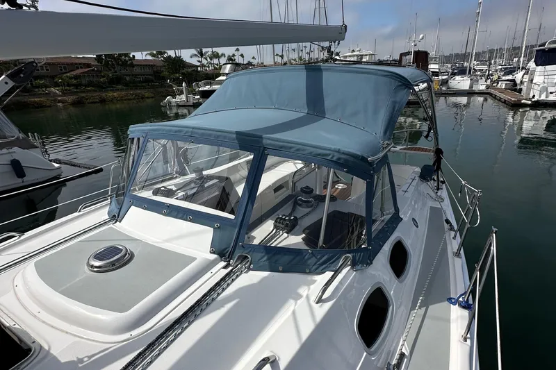 Slide: The Image of 2008 Hunter 36 sailboat with blue canopy docked in marina. - 22