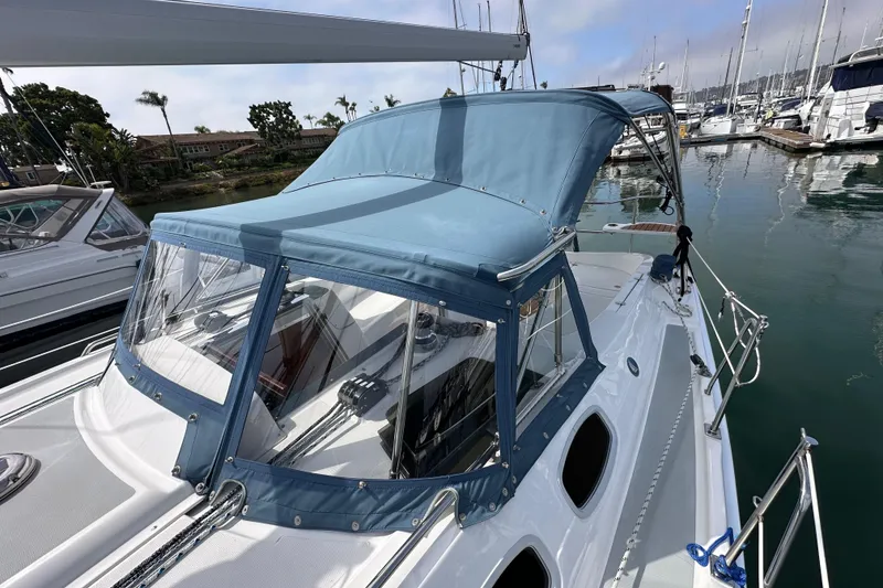 Slide: The Image of 2008 Hunter 36 sailboat with blue canopy docked in marina. - 23