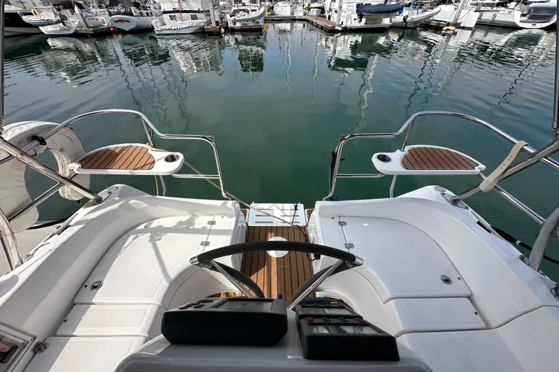 Slide: The Image of 2008 Hunter 36 sailboat cockpit with wooden accents, docked in a marina. - 26