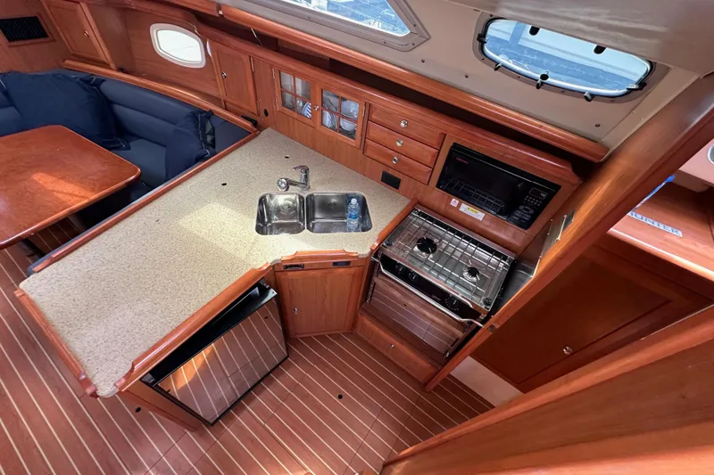 Slide: The Image of 2008 Hunter 36 yacht interior with kitchen, sink, stove, and seating area. - 45