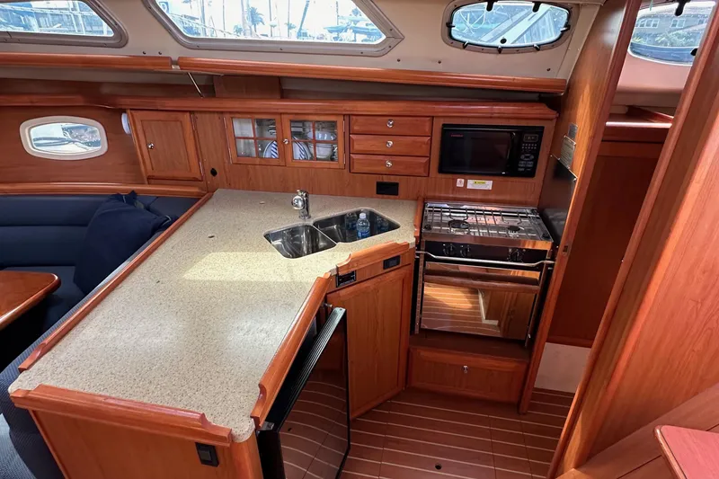 Slide: The Image of 2008 Hunter 36 yacht interior kitchen with wood cabinetry, sink, stove, and microwave. - 46