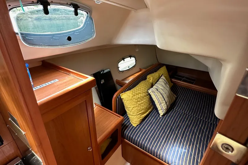Slide: The Image of Cozy cabin interior of 2008 Hunter 36 sailboat with striped bedding and wooden furnishings. - 50