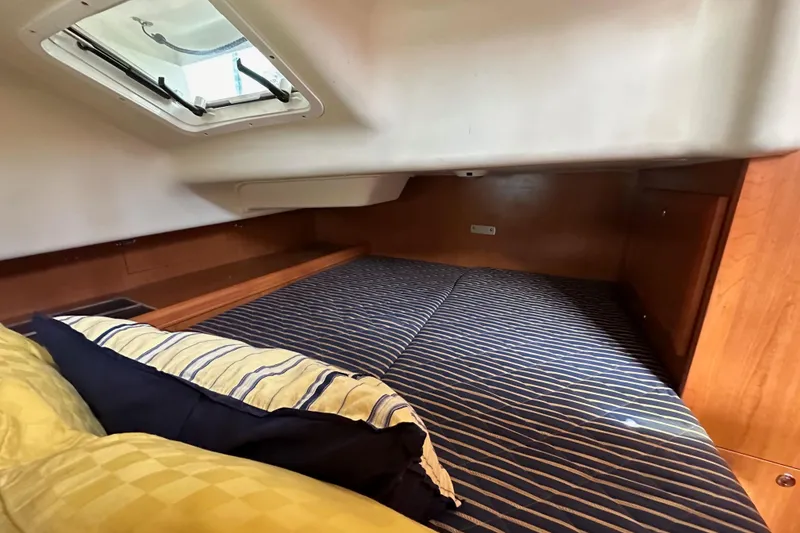 Slide: The Image of Cozy cabin interior of 2008 Hunter 36 sailboat with striped bedding and overhead hatch. - 52