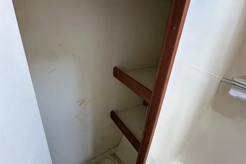 Slide: The Image of Empty wooden shelves inside a 2008 Hunter 36 sailboat storage compartment. - 59