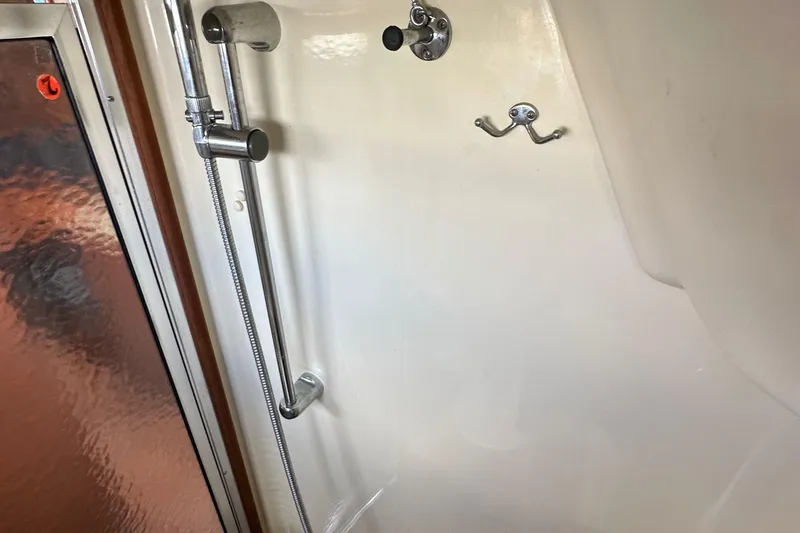 Slide: The Image of Shower area in a 2008 Hunter 36 boat, featuring chrome fixtures and frosted glass door. - 61