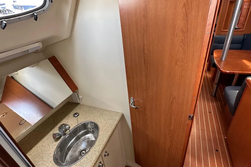 Slide: The Image of Interior of 2008 Hunter 36 sailboat showing bathroom sink and cabin area. - 63