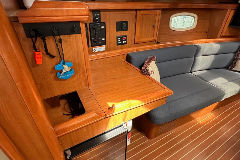 Slide: The Image of Interior of a 2008 Hunter 36 sailboat with wooden cabinetry and blue cushioned seating. - 66