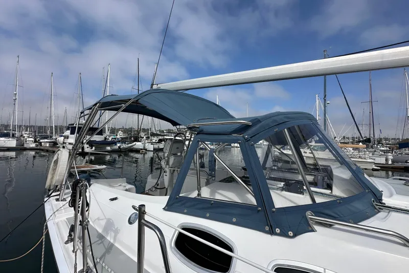 Slide: The Image of 2008 Hunter 36 sailboat docked in marina, featuring blue canopy and clear windows. - 7