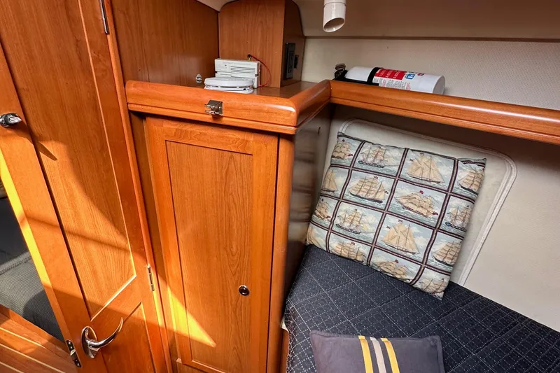 Slide: The Image of Interior of 2008 Hunter 36 sailboat with wooden cabinetry and nautical-themed cushion. - 79