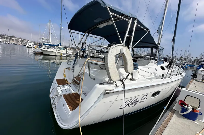 Slide: The Image of 2008 Hunter 36 sailboat docked in marina, featuring blue canopy and lifebuoy. - 9