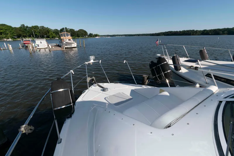 Slide: The Image of 2003 Carver 350 Mariner yacht docked on a serene lake with clear skies. - 12