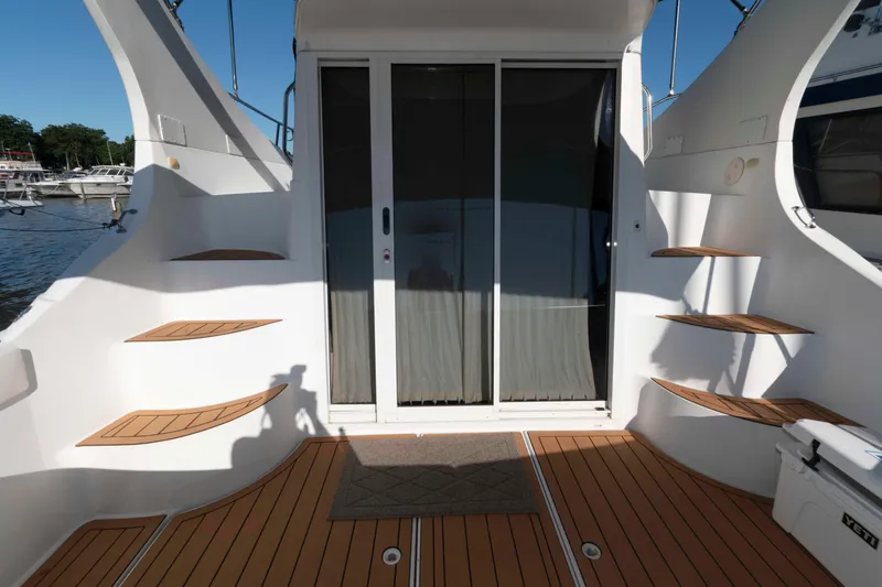 Slide: The Image of 2003 Carver 350 Mariner yacht deck with wooden steps and sliding glass door. - 2