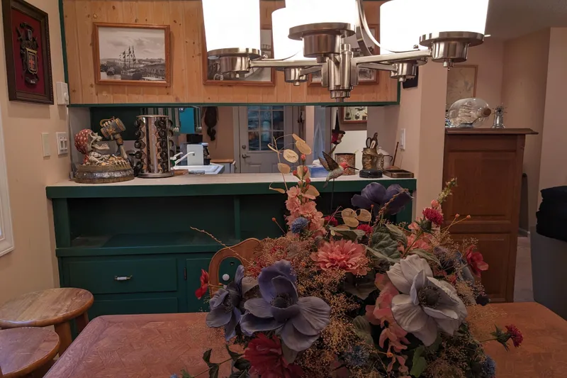 Slide: The Image of Cozy vintage kitchen with green cabinets, wooden shelves, and decorative items. - 13