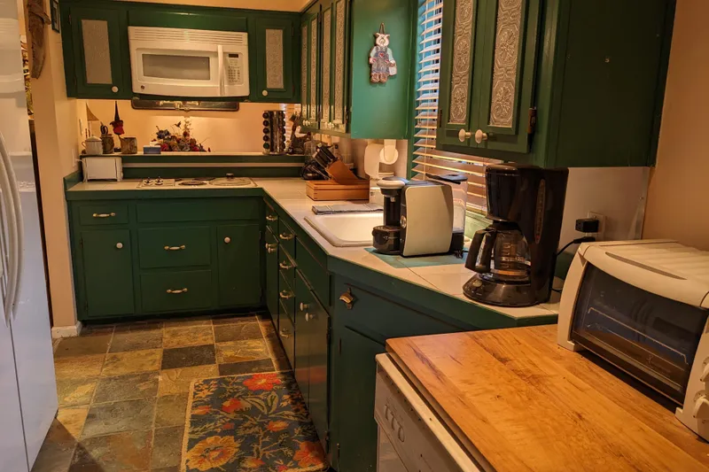 Slide: The Image of Cozy vintage kitchen with green cabinets, white appliances, and decorative accents. - 15