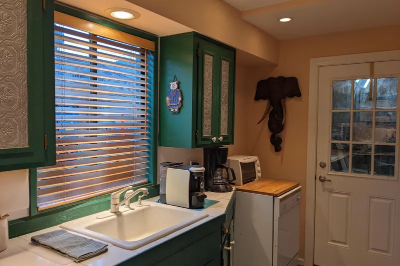 Slide: The Image of Cozy vintage kitchen with green cabinets, appliances, and colorful rug on tiled floor. - 16