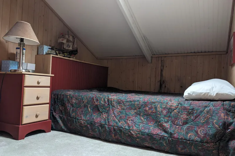 Slide: The Image of Cozy attic bedroom with vintage decor, patterned bedspread, and wooden walls. - 18