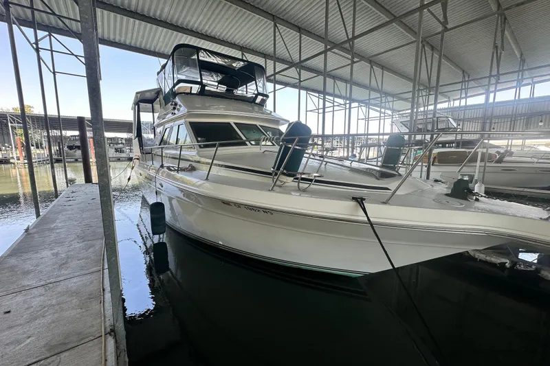 Slide: The Image of 1990 Sea Ray 380 Aft Cabin yacht docked in a covered marina. - 10