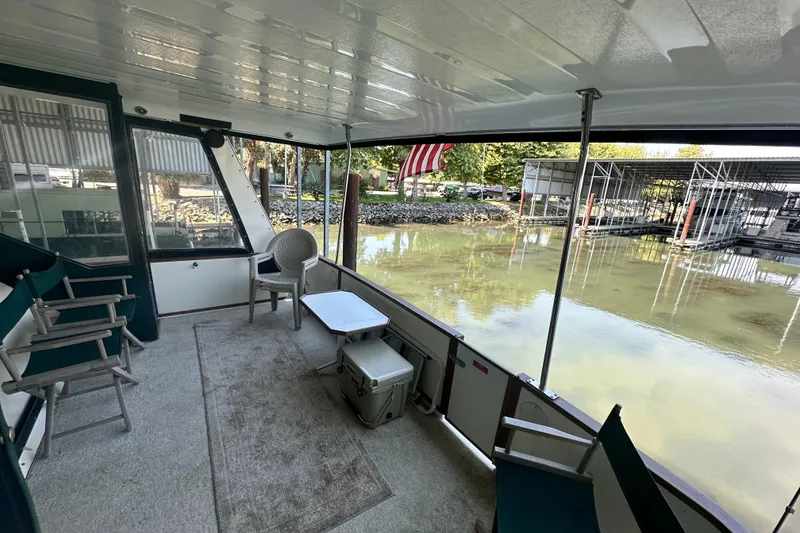 Slide: The Image of 1990 Sea Ray 380 Aft Cabin boat interior with seating, table, and water view. - 16