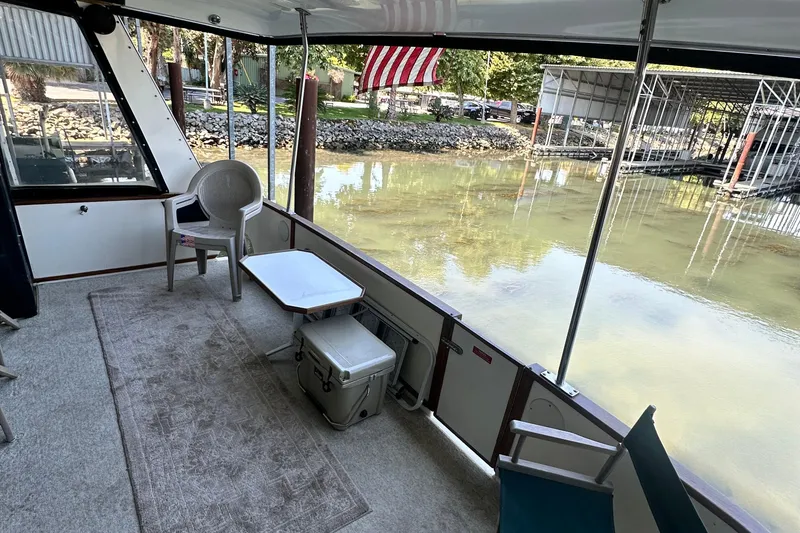 Slide: The Image of 1990 Sea Ray 380 Aft Cabin boat interior with chairs, table, and water view. - 17