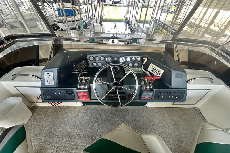 Slide: The Image of 1990 Sea Ray 380 Aft Cabin helm with steering wheel and control panel. - 22