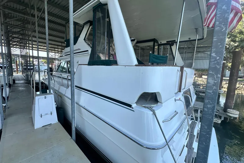 Slide: The Image of 1990 Sea Ray 380 Aft Cabin yacht docked in a covered marina. - 3