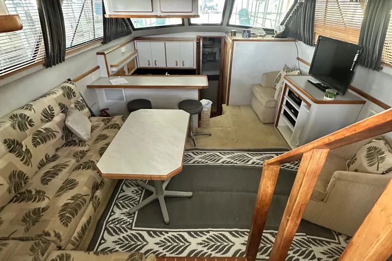 Slide: The Image of Cozy interior of 1990 Sea Ray 380 Aft Cabin with seating, table, and TV. - 30