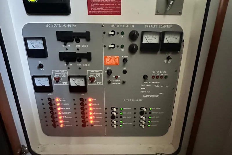 Slide: The Image of Electrical control panel of a 1990 Sea Ray 380 Aft Cabin boat, showing gauges and switches. - 34