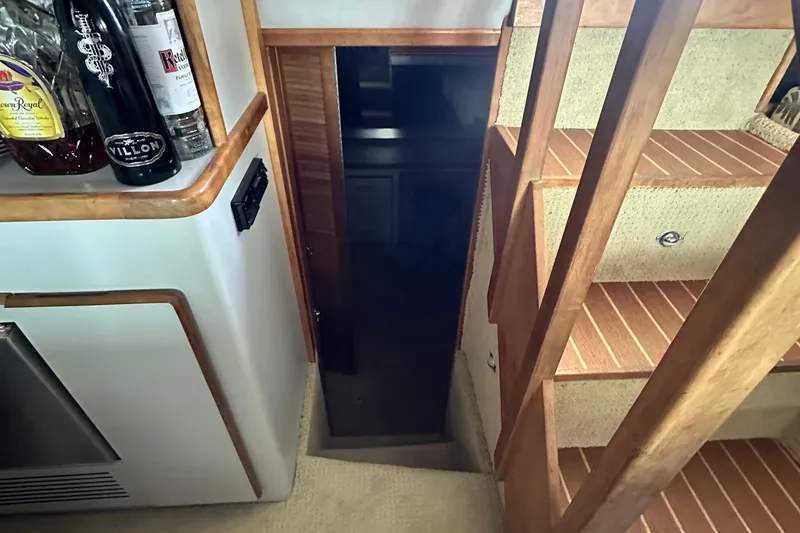 Slide: The Image of 1990 Sea Ray 380 Aft Cabin interior with wooden stairs and bar area. - 38