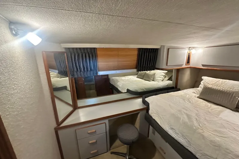 Slide: The Image of 1990 Sea Ray 380 Aft Cabin bedroom with bed, mirror, and cozy lighting. - 39