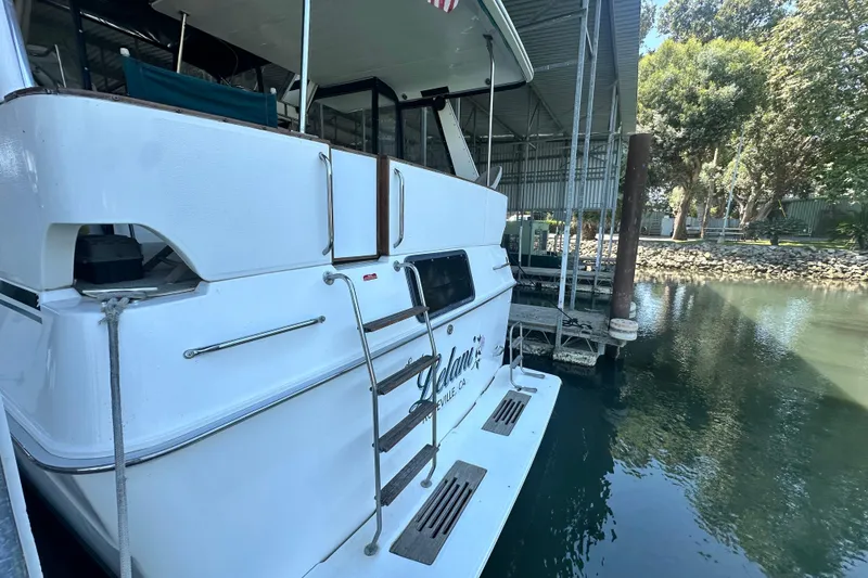Slide: The Image of 1990 Sea Ray 380 Aft Cabin yacht docked in a marina, rear view. - 4
