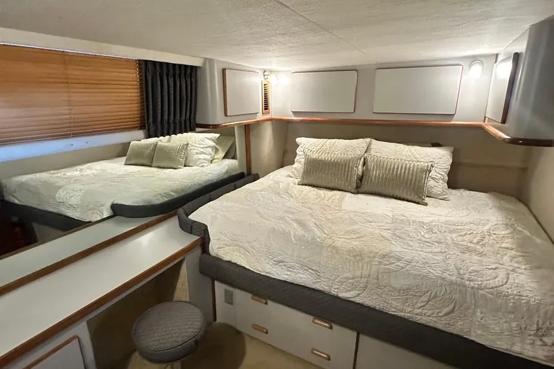 Slide: The Image of 1990 Sea Ray 380 Aft Cabin bedroom with cozy bed, pillows, and wooden blinds. - 42