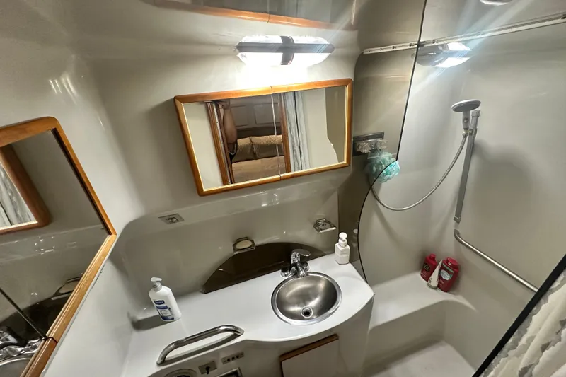 Slide: The Image of 1990 Sea Ray 380 Aft Cabin bathroom with sink, mirror, and shower area. - 43