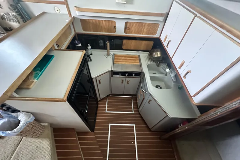 Slide: The Image of 1990 Sea Ray 380 Aft Cabin kitchen with wood accents and modern appliances. - 49