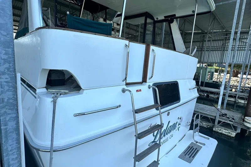 Slide: The Image of 1990 Sea Ray 380 Aft Cabin yacht docked in a marina, rear view. - 5