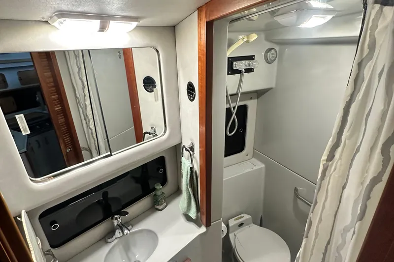 Slide: The Image of Bathroom interior of 1990 Sea Ray 380 Aft Cabin yacht, featuring sink, mirror, and shower. - 53