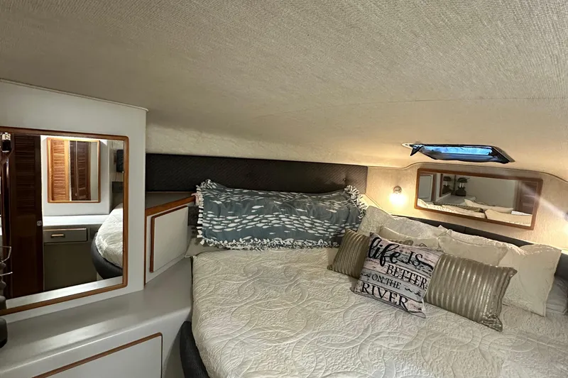Slide: The Image of 1990 Sea Ray 380 Aft Cabin interior with cozy bed and decorative pillows. - 56