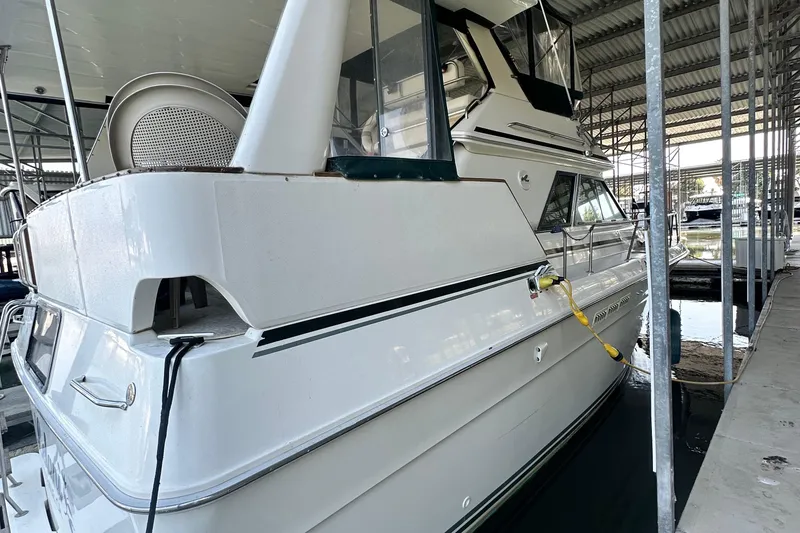 Slide: The Image of 1990 Sea Ray 380 Aft Cabin yacht docked in a covered marina. - 6