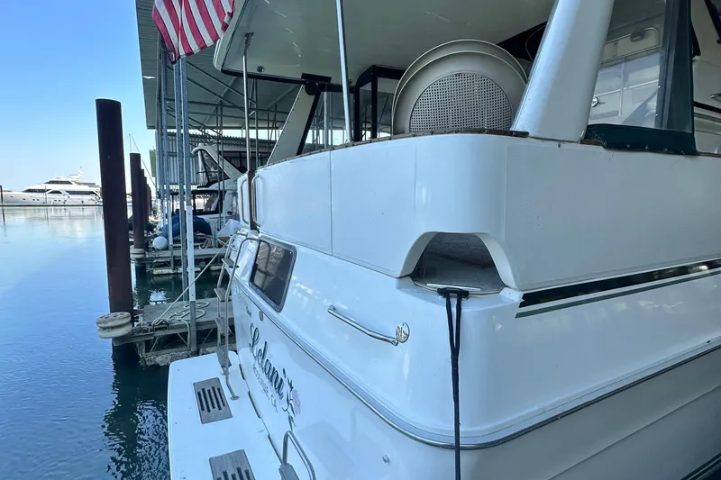 Slide: The Image of 1990 Sea Ray 380 Aft Cabin yacht docked in a marina with American flag. - 7