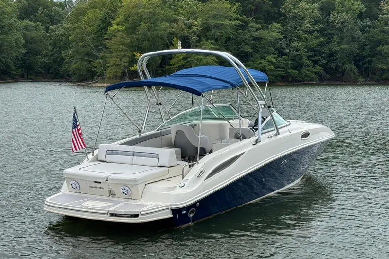 Slide: The Image of 2009 Sea Ray 280 Sundeck boat with blue canopy on a serene lake. - 10
