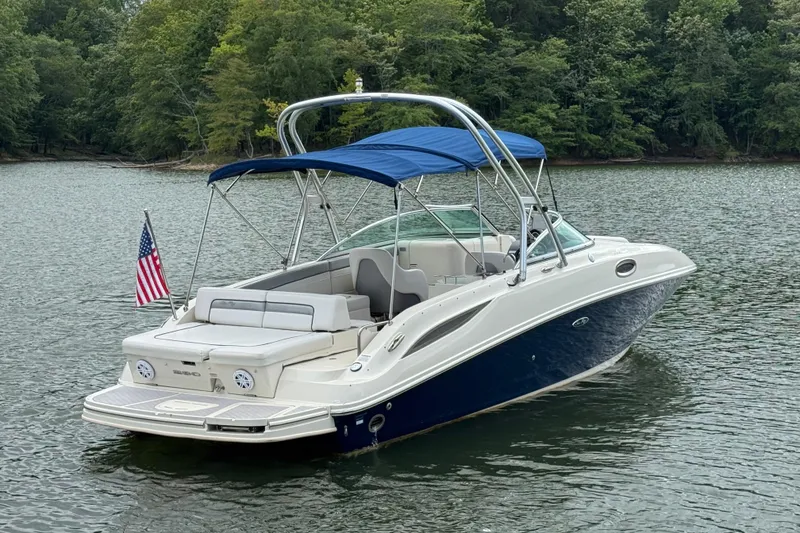 Slide: The Image of 2009 Sea Ray 280 Sundeck boat with blue canopy on a serene lake. - 11