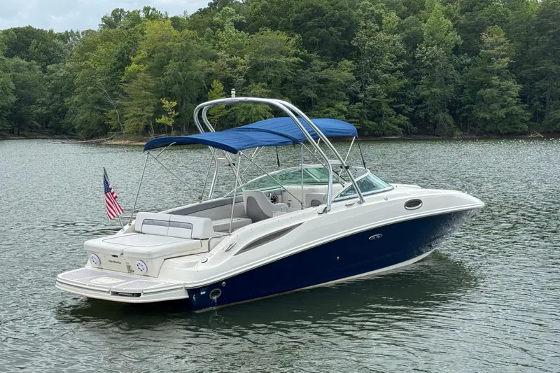 Slide: The Image of 2009 Sea Ray 280 Sundeck boat on a serene lake with lush green trees. - 13