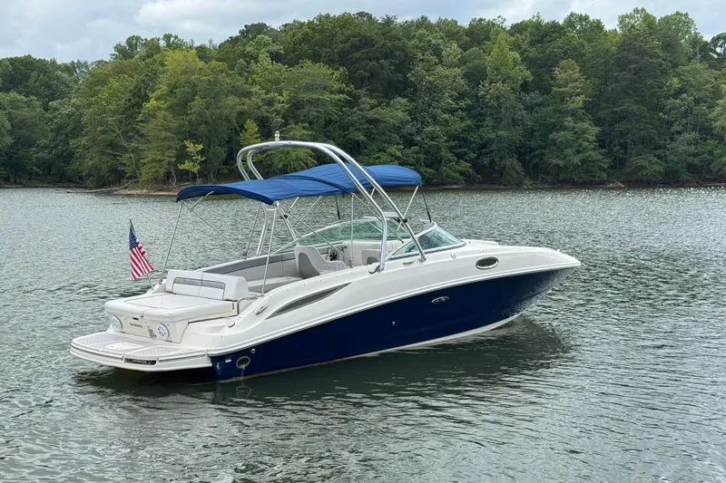 Slide: The Image of 2009 Sea Ray 280 Sundeck boat on a serene lake with lush green trees. - 14