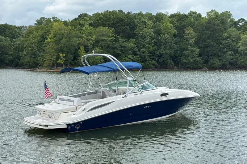 Slide: The Image of 2009 Sea Ray 280 Sundeck boat on a calm lake with forested shoreline. - 15