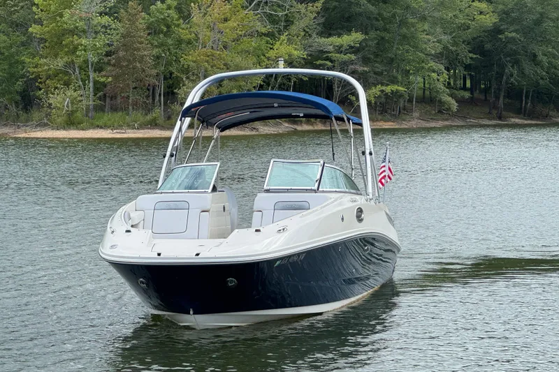 Slide: The Image of 2009 Sea Ray 280 Sundeck boat on a serene lake with forest backdrop. - 16
