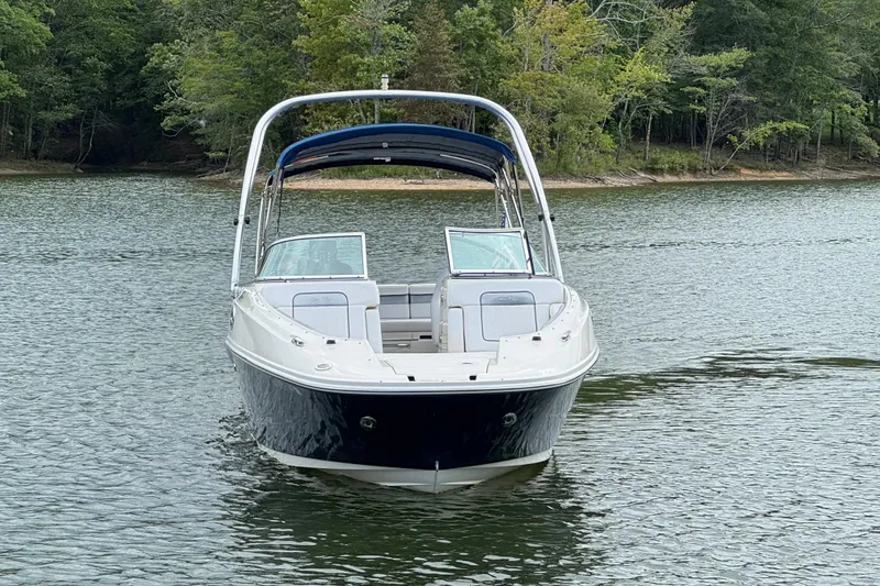 Slide: The Image of 2009 Sea Ray 280 Sundeck boat on a calm lake with forested shoreline. - 18
